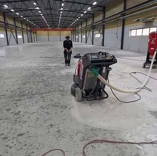 Arbetare med borrmaskin på byggarbetsplats